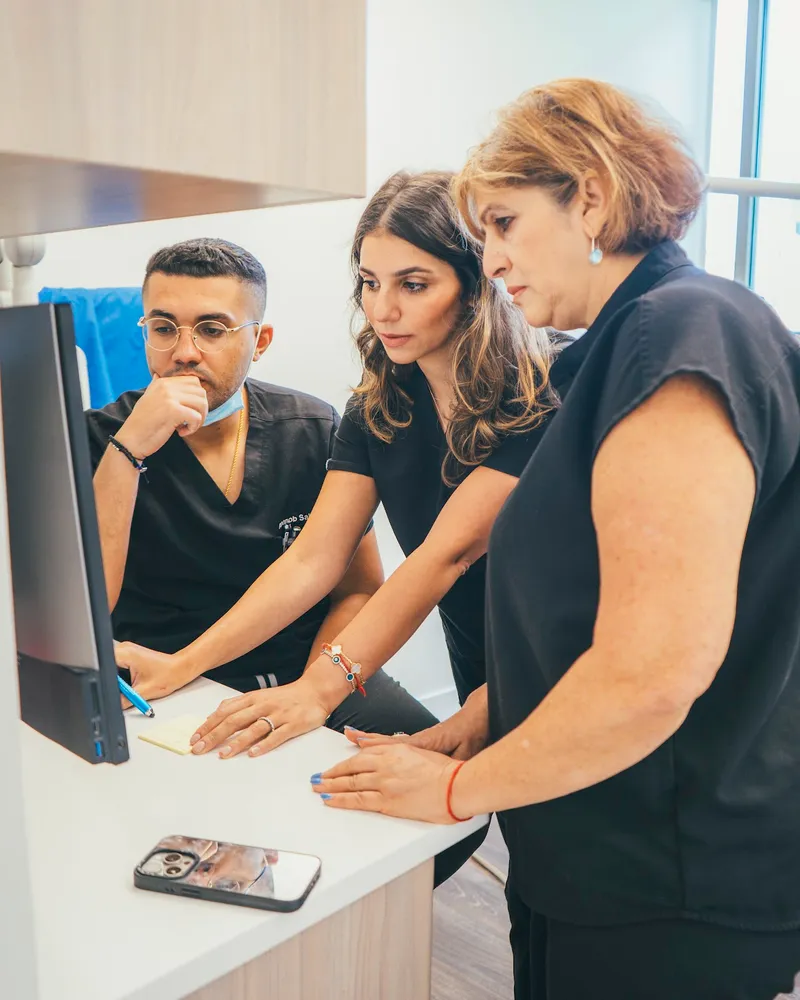 Dr. Abanob Saleh, Dr. Yelena Mikhaylova, and Dr. Alla Hart reviewing a case together at Thrive Dental Bayside